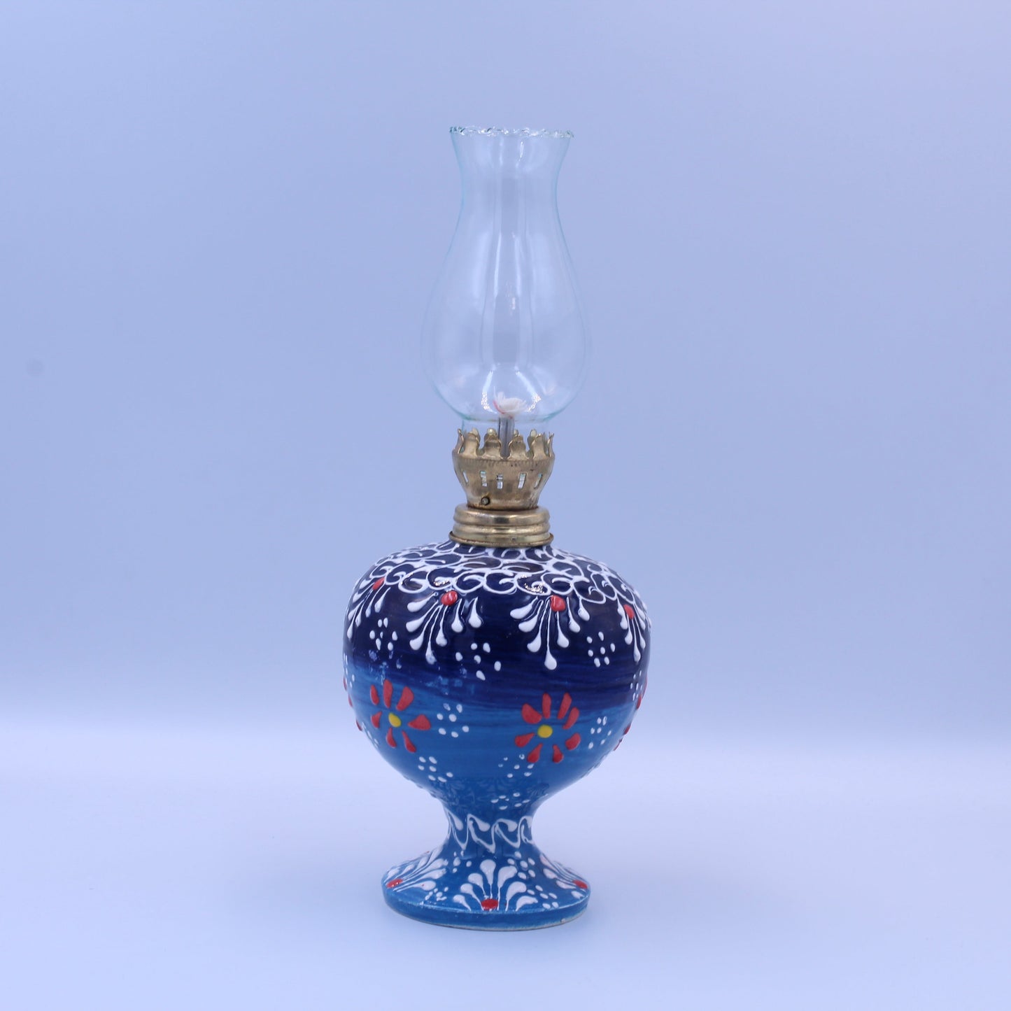Blue oil lamp with floral patterns on a white background