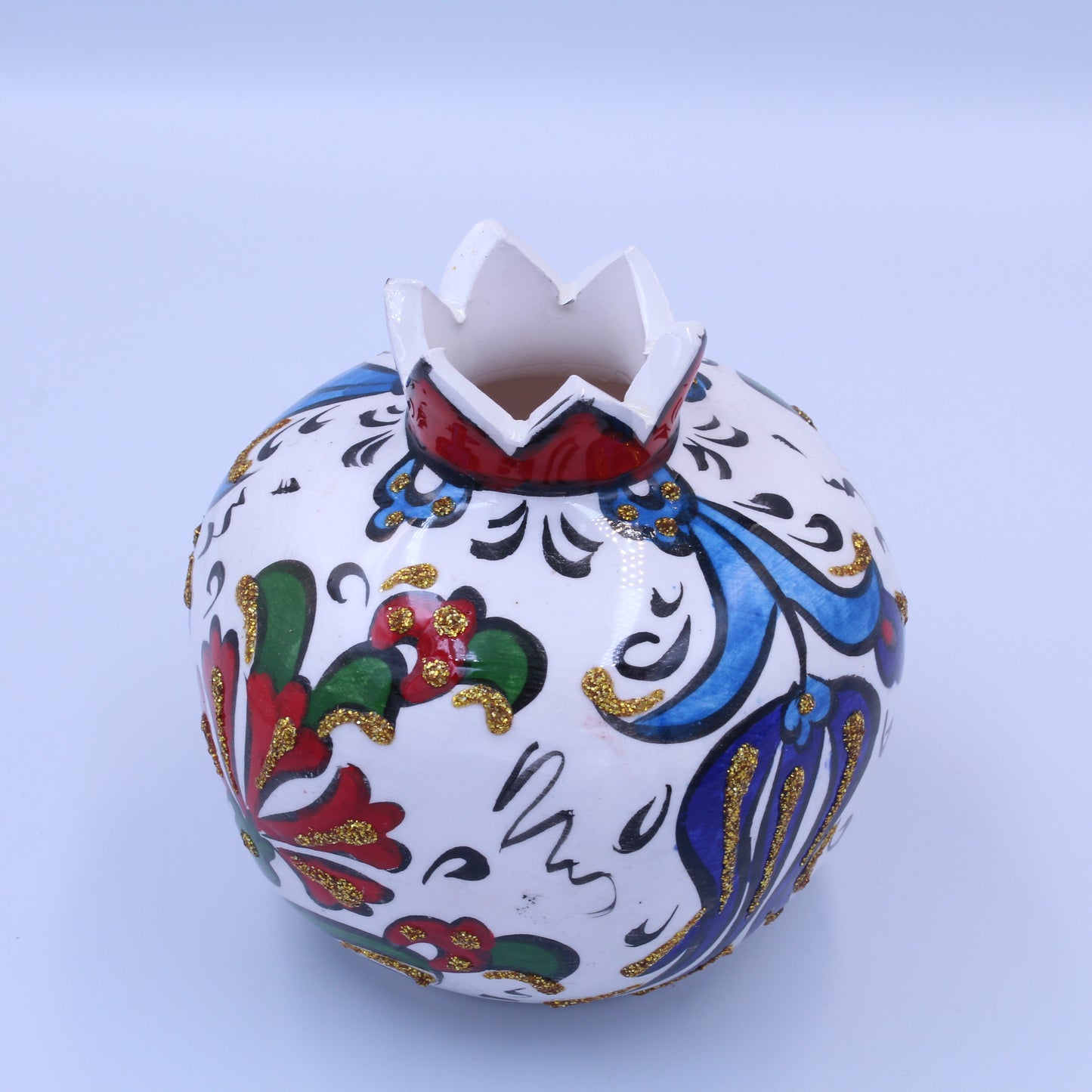 Decorative ceramic pot with colorful patterns on a light blue background