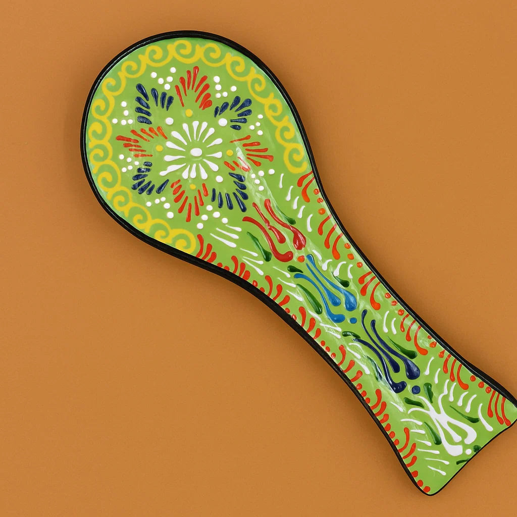 Decorative spoon rest with colorful patterns on a brown background