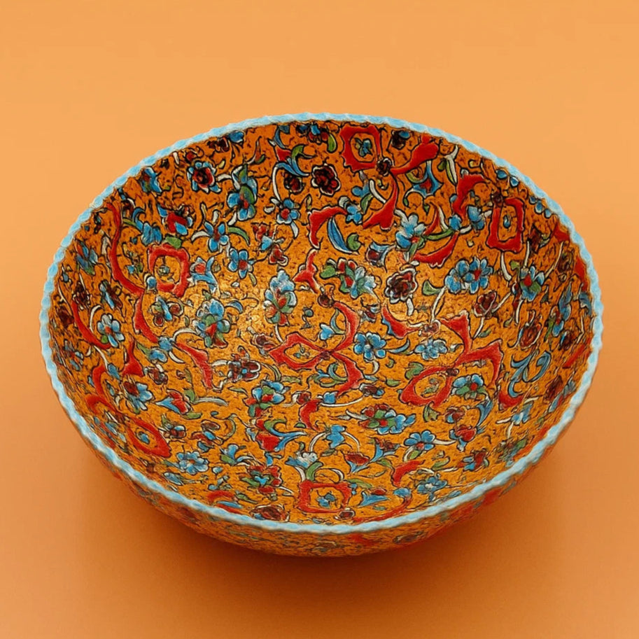 Decorative bowl with colorful floral pattern on an orange background